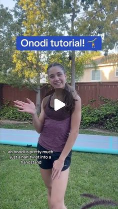 a girl is standing in the grass with her hands out and smiling at the camera