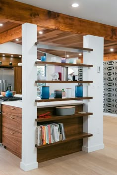 a kitchen with wooden shelves and white walls