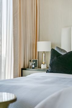 a bed with white sheets and black pillows