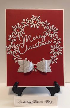 a christmas card with silver bows and snowflakes on it, in front of a red background