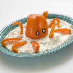 an orange and white octopus on top of rice in a blue bowl with spoons