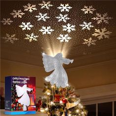 a christmas tree with snowflakes hanging from it's ceiling and an angel on top