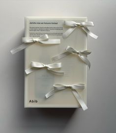 the box is wrapped in white paper with silver ribbons on it and has an ad for abid