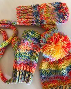 multicolored knitted mittens and gloves laying on top of each other