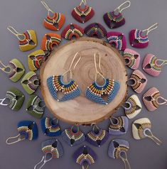 a group of colorful earrings sitting on top of a wooden table next to each other