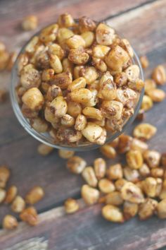 a glass bowl filled with nuts on top of a wooden table