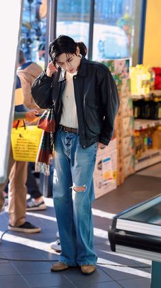 a man standing in front of a store talking on a cell phone