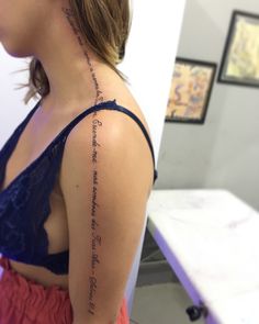 the back of a woman's shoulder with writing on it