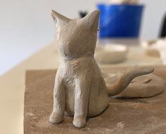 a clay cat sitting on top of a table