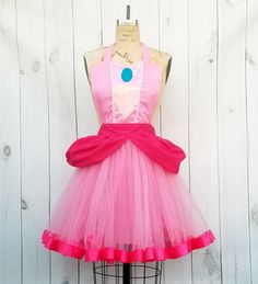 a dress on a mannequin with pink and blue trims, sitting on top of a dummy