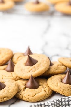 chocolate - covered cookies are piled on top of each other in front of more cookies