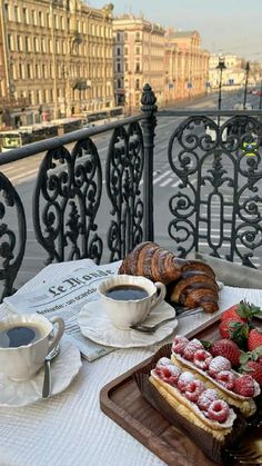 there is a tray with pastries on the table next to a cup of coffee