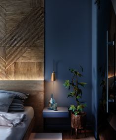 a bedroom with blue walls and wooden headboard next to a small plant in a vase