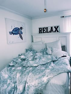 there is a bed that has a turtle on the wall above it and some pillows