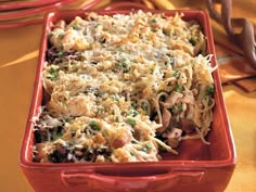 a red casserole dish filled with pasta and vegetables