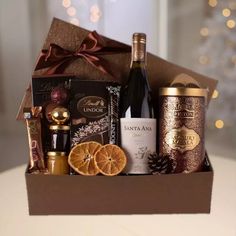 a bottle of wine, orange slices and chocolates in a gift box