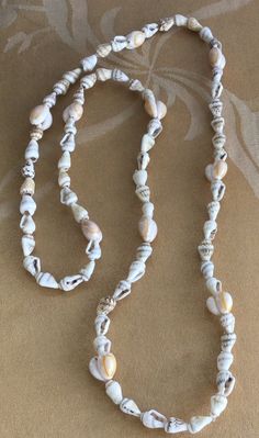 "Featuring this lovely beige and cream shell beaded necklace. It measures 34\" in length and is in very good vintage condition. The necklace does not have a clasp." Cheap Shell Beaded Strand Necklace, White Beaded Long Shell Necklace, Beach Inspired Jewelry, Hand-strung White Necklaces For Beach, White Long Beaded Necklace For Beach, Long White Beaded Necklace For Beach, White Long Shell Necklace For Beach, Beige Long Necklace For Beach, Vintage White Beaded Shell Necklace