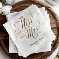 napkins that say from miss to mrs on top of a wooden plate with flowers