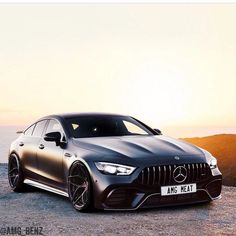 the mercedes amg cla is parked on top of a hill overlooking the ocean