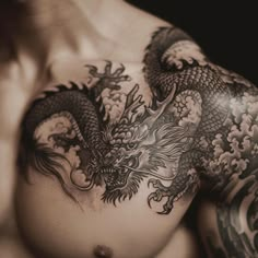 a man with dragon tattoos on his chest