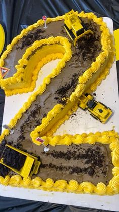 a cake shaped like the number two with construction trucks on it