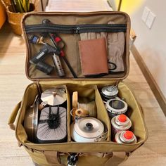 an open suitcase filled with various items on the floor