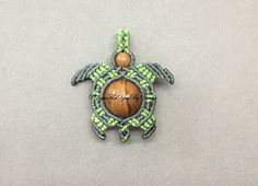 a beaded turtle ornament with a wooden ball on it's back