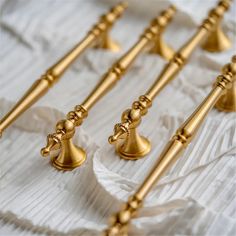 several golden candlesticks lined up on a white cloth