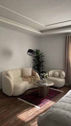 a living room filled with furniture next to a window and a rug on top of a hard wood floor