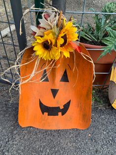 a pumpkin shaped planter with sunflowers in it