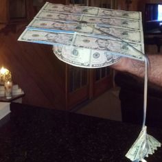 a man holding up a bunch of money on top of a counter