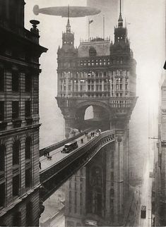 an old black and white photo of people walking on a bridge in the middle of a city