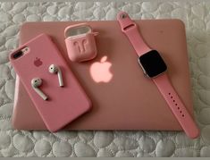 an apple watch, headphones and pink iphone case on a white tablecloth background