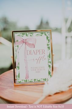 a sign that is sitting on top of a wooden table next to a white feather