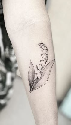 a small lily of the valley tattoo on the arm