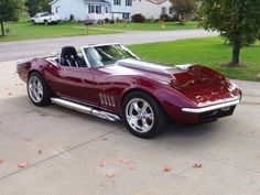 a red car is parked in the driveway