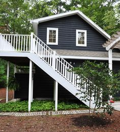 a house with stairs leading up to the front door and second story on top of it