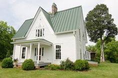 a white house with a green metal roof