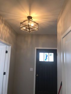 the light is on above the door in the house's entryway, which also has a black front door