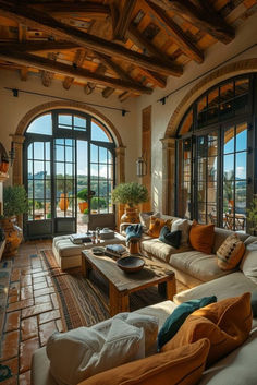 a living room filled with lots of furniture next to large arched windows and doors that open onto a balcony