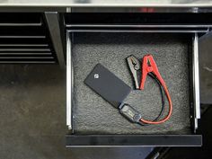 a pair of pliers and a battery in a drawer