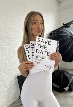 a woman in white tights holding up two signs that say save the date and no end