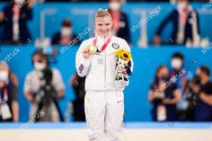 a woman standing on top of a wrestling ring holding two gold medals in her hands