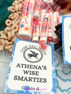 there are some candy and other snacks on the table with tags that say, athena's wise smarties