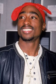 a man wearing a red hat and leather jacket