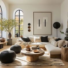 a living room filled with lots of furniture next to large windows and potted plants