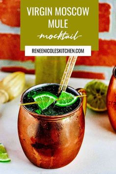 a moscow mule cocktail in a copper mug with lime wedges on the rim and green garnish