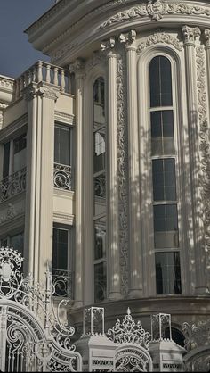 a large white building with a clock on it's face and balcony railings