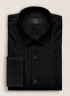 Create a timeless and elegant appearance. Our Pleated Black Tuxedo Shirt is a sophisticated choice for dress suits and tuxedos. Cut from the finest cotton, the shirt has a subtle luster and feel. Pleated bibs feature vertical pleats that run up both sides of the button placket and are a traditional detail on tuxedo shi Elegant Long Sleeve Dress Shirt For Semi-formal Occasions, Formal Black Cotton Dress Shirt, Business Tuxedo Shirt With Long Sleeves, Luxury Slim Fit Dress Shirt For Formal Occasions, Luxury Slim Fit Formal Dress Shirt, Classic Party Tops With Spread Collar, Fitted Black Top For Formal Occasions, Fitted Tuxedo Shirt For Formal Occasions, Formal Fitted Tuxedo Shirt