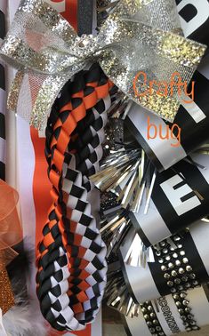 an orange, black and white ribbon is tied to the side of a large bow